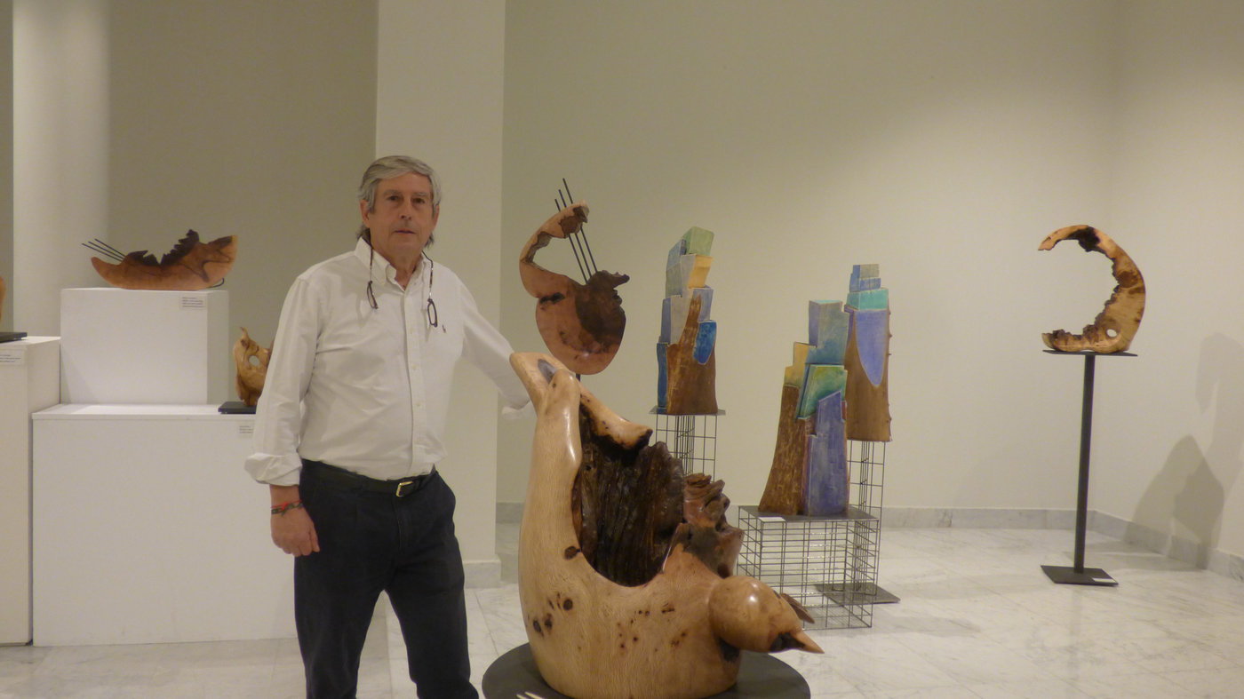 José Luis García Martín junto a sus esculturas en una exposición